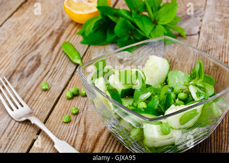 Avec salade de concombre, le pourpier et les pois verts sur les disques sombres Banque D'Images