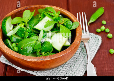 Avec salade de concombre, le pourpier et les pois verts sur les disques sombres Banque D'Images