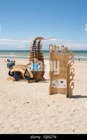 Une sculpture promeut la sensibilisation à l'environnement sur la plage et dans la mer tout en combinant deux corbeilles. Banque D'Images