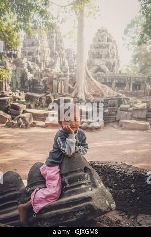 Angkor Wat, au Cambodge - Août 2007 : jeune fille assise sur les ruines de l'un des temples à Angkor Wat, au Cambodge complexe Banque D'Images