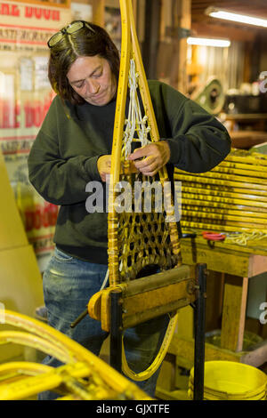 Shingleton, Michigan - Julie Holmes strings raquettes à l'usine d'Iverson. Banque D'Images