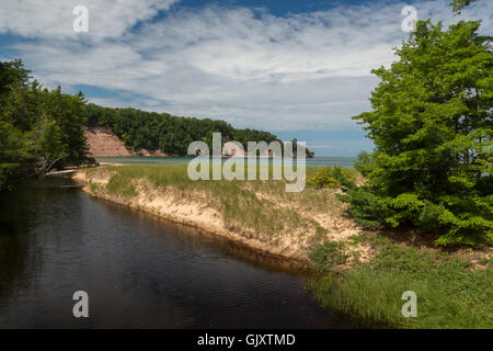 Munising, Michigan - Lumière du Nord Creek comme il se jette dans le lac Supérieur sur la plage du nord à distance sur Grand Island. Banque D'Images