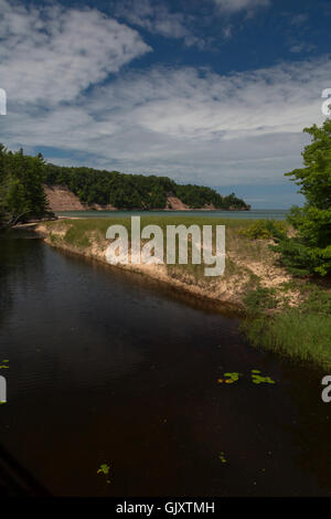 Munising, Michigan - Lumière du Nord Creek comme il se jette dans le lac Supérieur sur la plage du nord à distance sur Grand Island. Banque D'Images