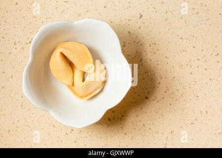 Deux Chinois fortune cookies dans un bol en céramique blanche sur un comptoir en quartz pierre d'ingénierie haut de gamme contemporain accueil cuisine intérieur Banque D'Images