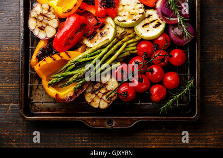 Légumes grillés sur une plaque de cuisson grille métallique sur fond de bois Banque D'Images