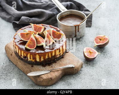 Fig fait maison avec sauce au caramel gâteau à balancier et figues fraîches sur planche de bois sur fond de béton gris, selective focus, ho Banque D'Images