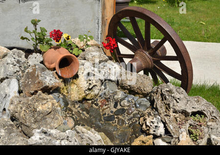 L'eau qui coule d'un pot en céramique décoration de jardin d'aspect ethnique Banque D'Images