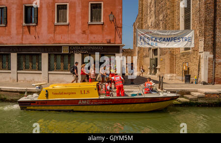 Patient de sexe féminin étant aidé par le personnel paramédical à bord d'une ambulance de l'eau. Venise, Murano, en Italie. Banque D'Images