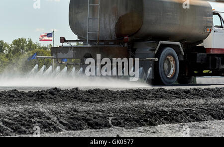 Le camion d'eau pulvériser de l'eau sur la chaussée dans la préparation en vue de la construction Banque D'Images