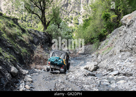 Jeep conduite le long d'une route inondée dans la vallée de Birir, nord du Pakistan. L'Birir vallée est habitée par les Kalash Banque D'Images