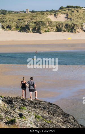 Deux personnes sur le stand et Pentire donnent sur plage de Crantock à Newquay, Cornwall. Banque D'Images