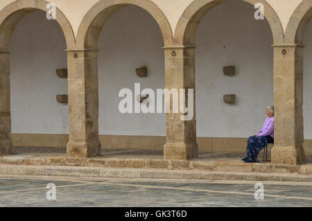 Une vieille femme assise à l'extérieur de la chapelle de São João da Pesqueira hameau. La Vallée du Douro. Le Portugal. L'Europe Banque D'Images