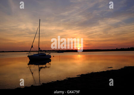 Petit yacht silhouette sur le coucher de soleil à Seascale Banque D'Images