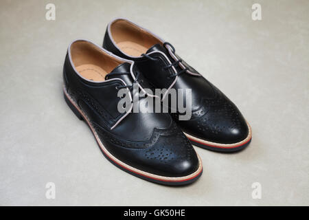 Noir brillant moderne mans chaussures avec lacets sur fond clair Banque D'Images