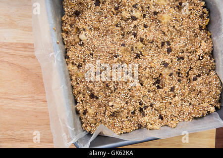 Moule à gâteau plein de bars et de l'avoine quinoa prêt à cuire la pâte Banque D'Images