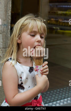 Adorable young girl eating chocolate ice cream cone Banque D'Images