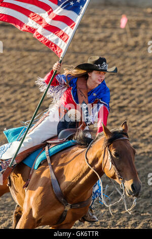 La Reine du rodéo à cheval avec le drapeau américain ; Chaffee County Fair & Rodeo, Salida, Colorado, USA Banque D'Images