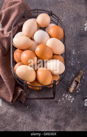 Oeufs dans le panier métallique sur fond gris vue ci-dessus Banque D'Images