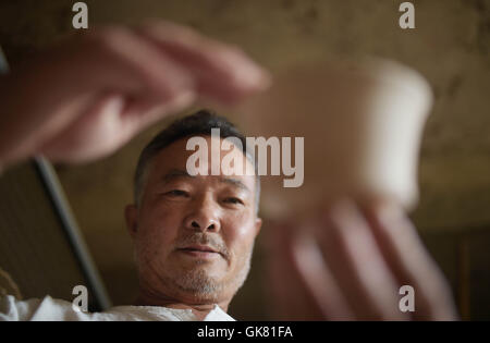 Huili, la province chinoise du Sichuan. Août 18, 2016. Han Jinfu, héritier de la technique de la poterie vernissée verte, les contrôles de base de la poterie dans la région de Huili County de Liangshan Préfecture autonome Yi, au sud-ouest de la province chinoise du Sichuan, le 18 août 2016. Le livre vert-poterie émaillée de Huili bénéficie d'une grande renommée dans le Sichuan. Il est nommé comme la poterie "vert" parce qu'il contient qui devient vert de malachite après la gravure à haute température. Il a été répertorié comme le patrimoine culturel immatériel du Sichuan en 2009. © Xue Yubin/Xinhua/Alamy Live News Banque D'Images