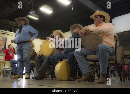 Elgin, en Floride, aux États-Unis. Nov 8, 2016. Une équipe tente de deviner qui a l 'OS'' comme ils jouent le jeu à la main pendant le Comanche fair à Elgin, Illinois. Les deux équipes jouant le jeu à la main peuvent varier en taille, chaque équipe (le ''cacher'' et ''l'équipe deviner'') de l'équipe doit avoir un capitaine. Le jeu se joue avec deux paires de 'bones', chaque paire composée d'un langage simple et un bar d'os. Chaque tribu décide de l'os sera deviné, la plaine ou à rayures de l'os. Arizona indiens pour l'appel en général l'os à rayures. Les deux équipes, un ''cacher'' et un ''devinant, '' s'asseoir en face de l'autre ; deux mem Banque D'Images