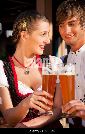 Couple in tracht boire la bière de froment Banque D'Images