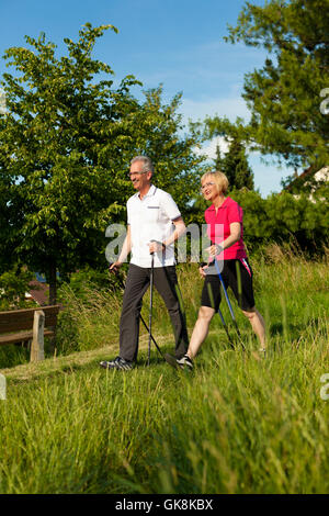 Heureux couple de personnes âgées la marche nordique en été Banque D'Images