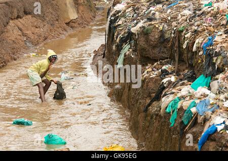 Enfant jouant dans la rivière fétide de Kibera. Banque D'Images