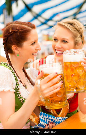 Les jeunes femmes en dirndl traditionnel dans une tente à bière Banque D'Images