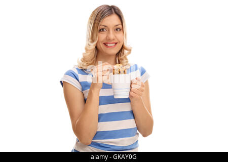 Smiling woman trempage d'un cookie dans un verre de lait isolé sur fond blanc Banque D'Images