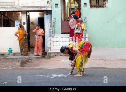 La farine de riz création femme ornement sur l'asphalte pour une fête religieuse en Inde, Tiruchirappalli Banque D'Images