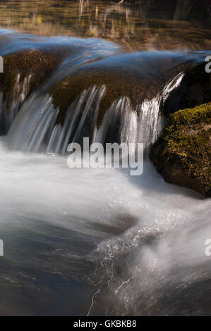 Une vitesse d'obturation lente, près d'un ruisseau Tumbling doucement sur les rochers - Gordale Beck, Malham, North Yorkshire, Angleterre. Banque D'Images