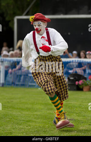 Amusement, bande dessinée, amuseurs. Clown en fuite  nez rouge Sunny the Clown, (Sonny et Rainbow), divertissez les enfants dans l'arène Southport Flower Show, Merseyside, Royaume-Uni Banque D'Images