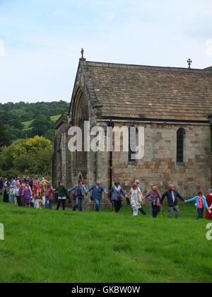 Clypping (ou 'CLIPPING') l'église de Wirksworth, Derbyshire - habitants de bras de liaison et 'embrace' l'église. Banque D'Images