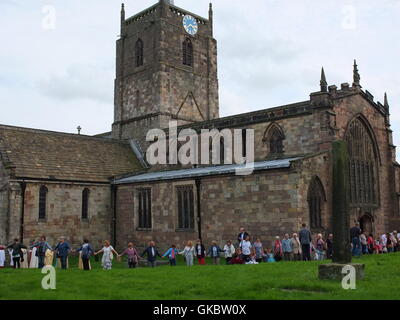 Clypping (ou 'CLIPPING') l'église de Wirksworth, Derbyshire - habitants de bras de liaison et 'embrace' l'église. Banque D'Images