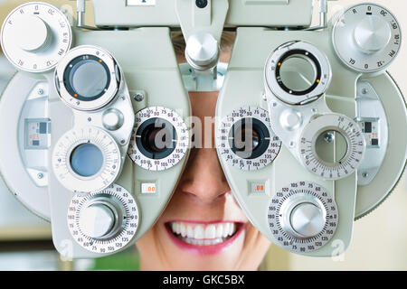 Jeune femme sur le phoropter pour essai d'oeil Banque D'Images