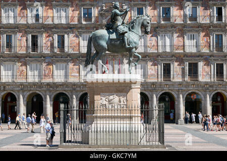 Les touristes à la recherche jusqu'à la statue de bronze du roi Philippe III sur la Plaza Mayor (place principale), Madrid, Espagne Banque D'Images