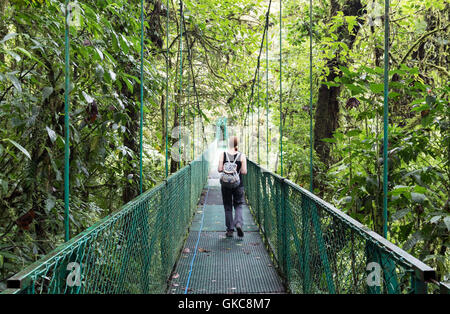 Touriste marcher sur un pont couvert de la canopée Monteverde, ponts à pied, Monteverde, Costa Rica, Amérique Centrale Banque D'Images