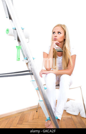 Une belle jeune femme blonde avoir une pause de l'emplacement sur une chaise et la pensée Banque D'Images