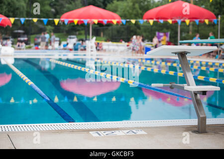 Un bloc de plongée se tient devant les voies de course vide dans une piscine Banque D'Images