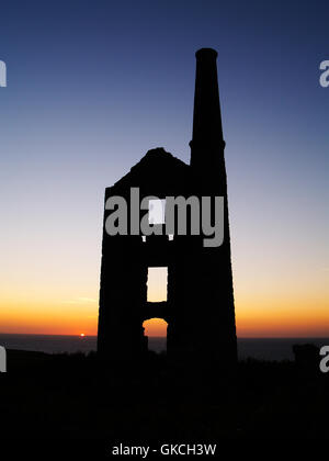 Le soleil se couche derrière une ancienne mine d'étain de Cornouailles engine house Banque D'Images