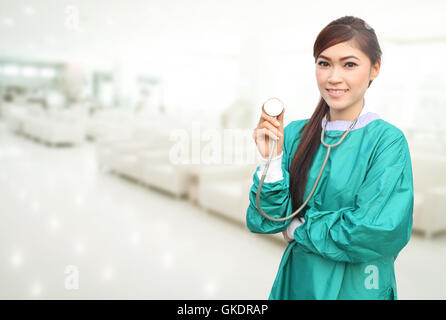 Femme médecin portant un stéthoscope et gommages vert en arrière-plan de l'hôpital Banque D'Images