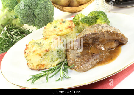 Médaillons de gibier avec gratin de pommes de terre et brocoli Banque D'Images