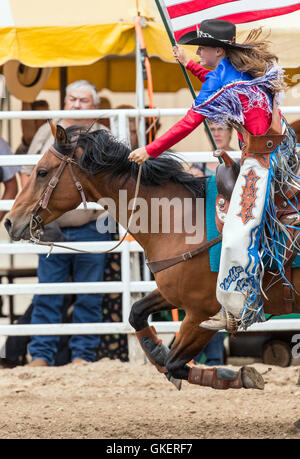 La Reine du rodéo à cheval avec le drapeau américain ; Chaffee County Fair & Rodeo, Salida, Colorado, USA Banque D'Images