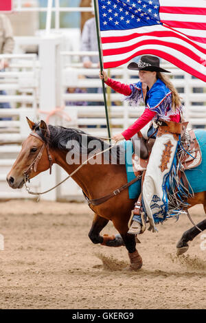 La Reine du rodéo à cheval avec le drapeau américain ; Chaffee County Fair & Rodeo, Salida, Colorado, USA Banque D'Images