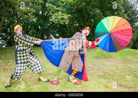 Southport, Merseyside. Météo France : 20 Aug 2016.Température : 20e Août 2016. Comme les grands vents et tempêtes frappé Southport, Sonny & Rainbow luttent pour conserver leurs parasols. Comme les deux clowns les plus drôles autour, ils peuvent transformer des situations de la vie quotidienne dans les scénarios drôles. Les foules étaient soufflés par leurs singeries comme le mauvais temps a frappé une fois de plus sur la foule dans le Southport Flower Show. Credit : Cernan Elias/Alamy Live News Banque D'Images