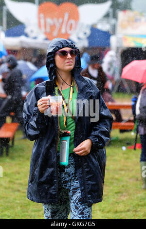 Green Man Festival, Crickhowell, Pays de Galles - Août 2016 - La pluie et plus de pluie au Green Man Festival avec quelques instants de soleil - Un ventilateur fait de son mieux pour rester au sec pour profiter de son cocktail. Banque D'Images