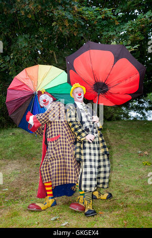 Clowns dans un gale à Southport, Merseyside. Météo au Royaume-Uni : 20 août 2016. Météo : alors que les vents violents et les gales frappent la station, Sonny & Rainbow luttent pour se tenir à leurs parapluies. Comme deux des clowns les plus drôles autour, Gordon Murray et Gary McBeth, peuvent transformer les situations quotidiennes en scénarios drôles. Les foules ont été balayées par leurs bouffonneries alors que le mauvais temps a frappé une fois de plus au-dessus de la foule au salon des fleurs de Southport. Banque D'Images