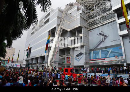 Bangladeshis se rassemblent pour surveiller les opérations de secours à l'extérieur du Bashundhara City shopping mall qui a pris feu à Dhaka, au Bangladesh. Le 21 août, 2016 quatorze unités du Service des incendies s'efforcent de contrôler la flamme. L'incendie a éclaté à shop 360 sur le bloc C de la Mall qui est un magasin de chaussures. L'incendie a éclaté vers 11h25 et soudain se répandre sur l'étage, a déclaré Abdur Rahman, au service de l'agent de service d'incendie de la salle de contrôle. Banque D'Images