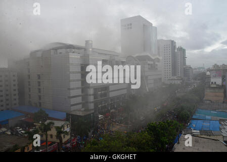 Bangladeshis se rassemblent pour surveiller les opérations de secours à l'extérieur du Bashundhara City shopping mall qui a pris feu à Dhaka, au Bangladesh. Le 21 août, 2016 quatorze unités du Service des incendies s'efforcent de contrôler la flamme. L'incendie a éclaté à shop 360 sur le bloc C de la Mall qui est un magasin de chaussures. L'incendie a éclaté vers 11h25 et soudain se répandre sur l'étage, a déclaré Abdur Rahman, au service de l'agent de service d'incendie de la salle de contrôle. Banque D'Images