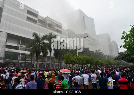 Bangladeshis se rassemblent pour surveiller les opérations de secours à l'extérieur du Bashundhara City shopping mall qui a pris feu à Dhaka, au Bangladesh. Le 21 août, 2016 quatorze unités du Service des incendies s'efforcent de contrôler la flamme. L'incendie a éclaté à shop 360 sur le bloc C de la Mall qui est un magasin de chaussures. L'incendie a éclaté vers 11h25 et soudain se répandre sur l'étage, a déclaré Abdur Rahman, au service de l'agent de service d'incendie de la salle de contrôle. Banque D'Images